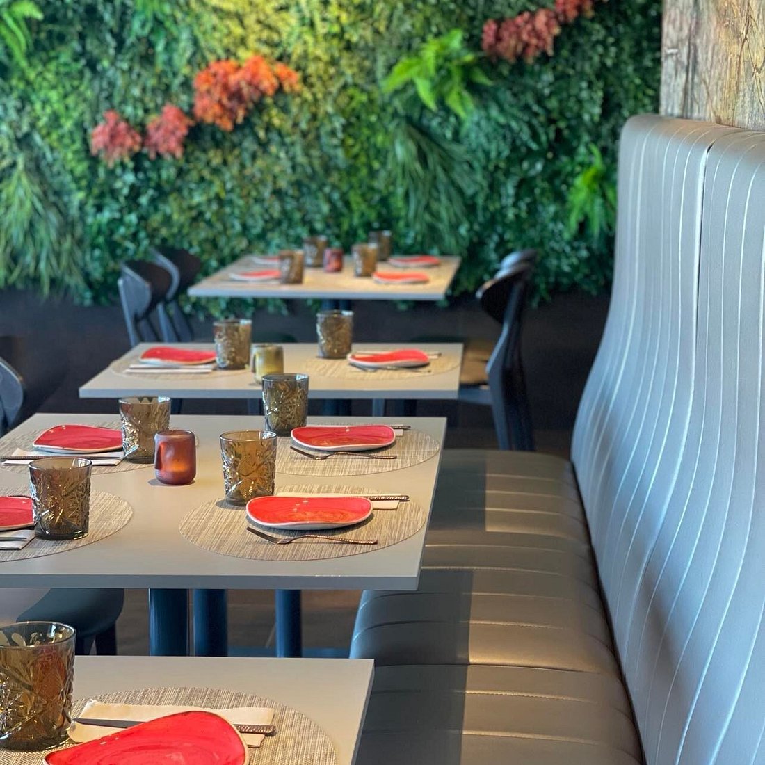 Mesas preparadas junto ao banco corrido e à parede vegetal do Assaturae
